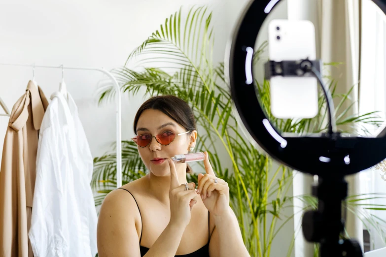 a woman brushes her teeth as she stands in front of the mirror