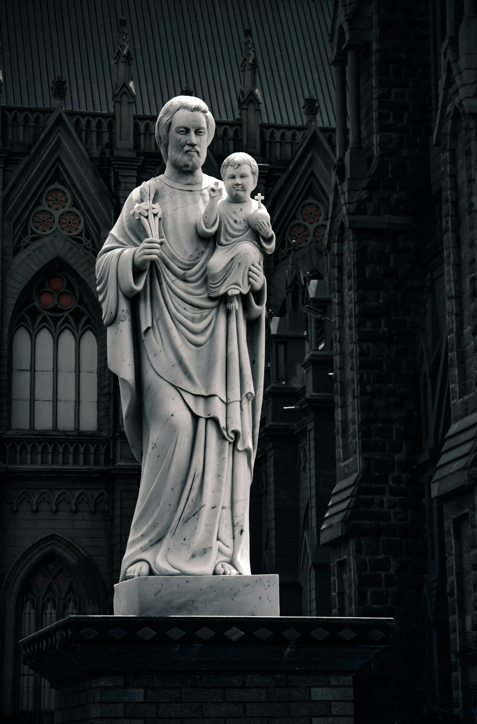 statue of virgin mary and child with an elaborate castle behind