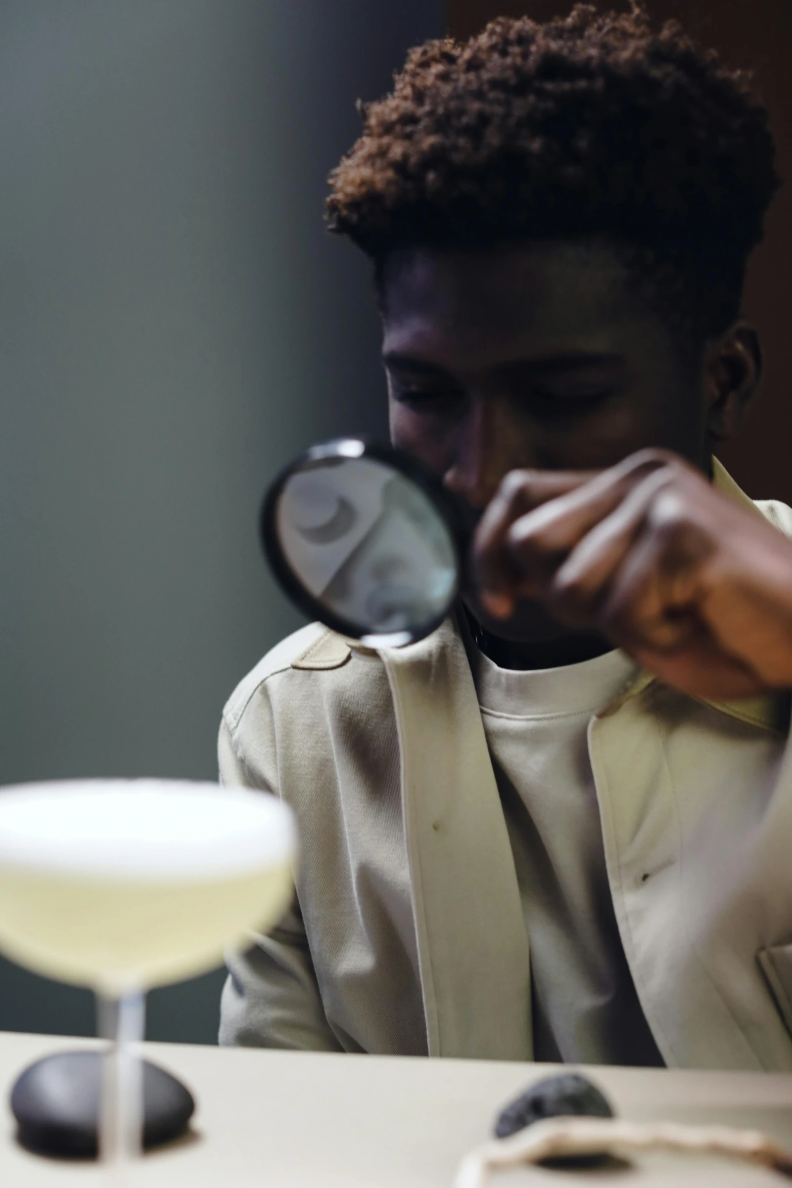 a man sitting at a table looking in the mirror