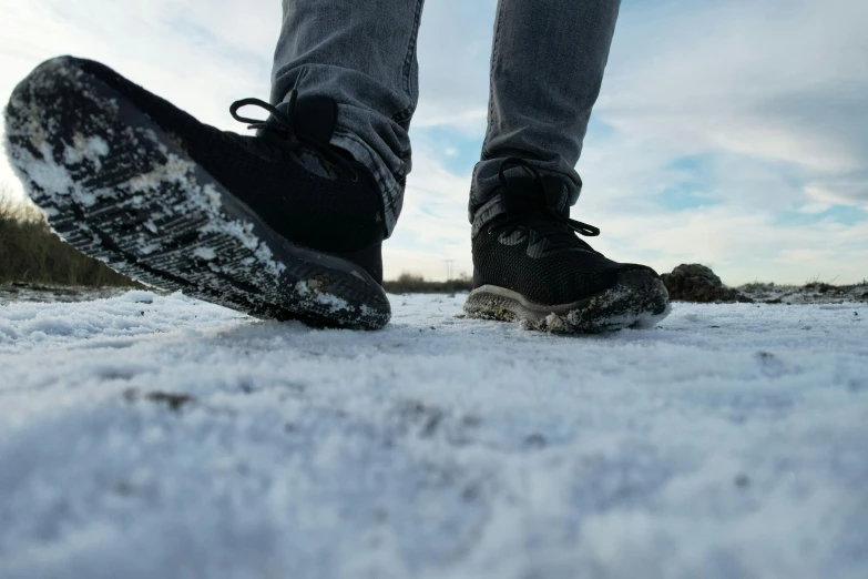 a person with boots is standing on snow