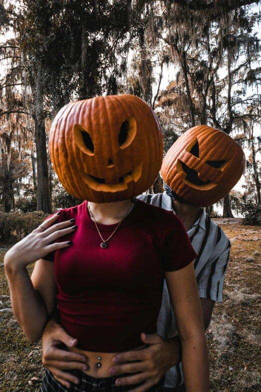 a man and a woman holding pumpkin heads in the air