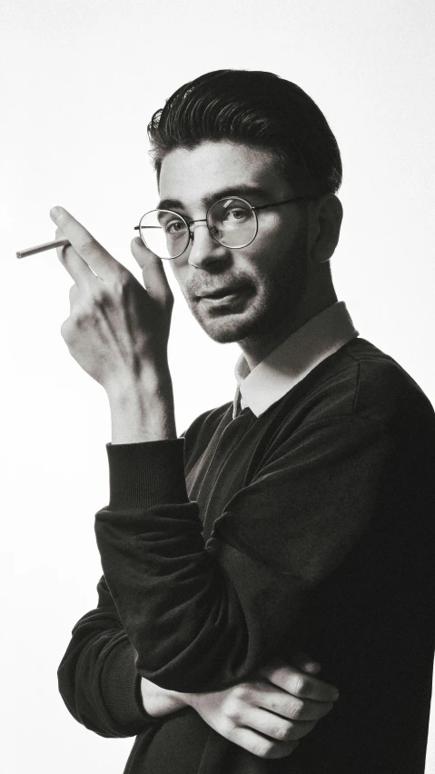 a man in glasses smoking with his hand crossed in his chin