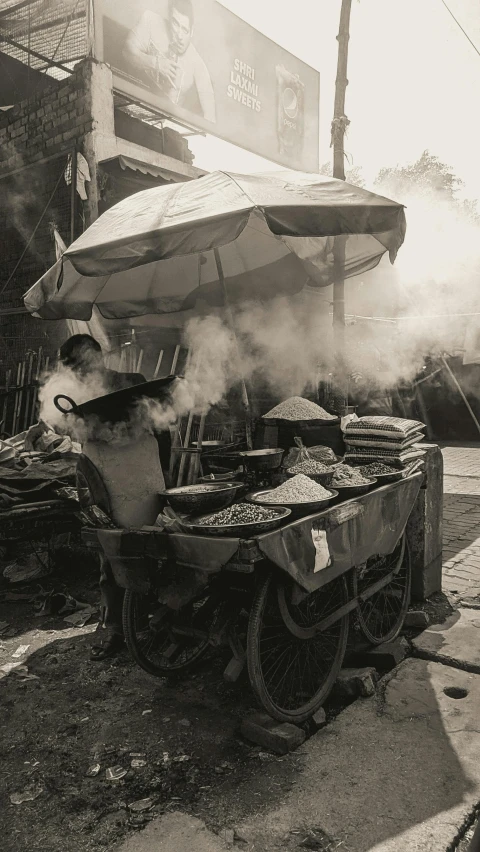 black and white image of a street vendor cart in a market