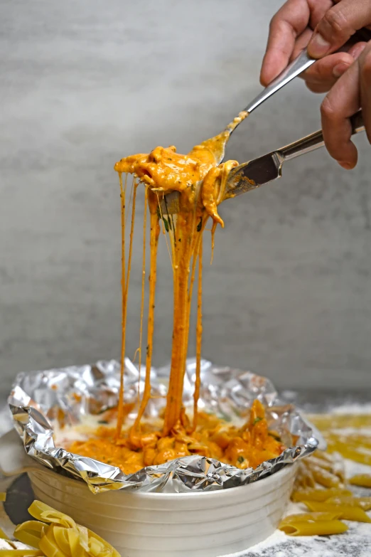 someone is holding a spatula over a casserole dish