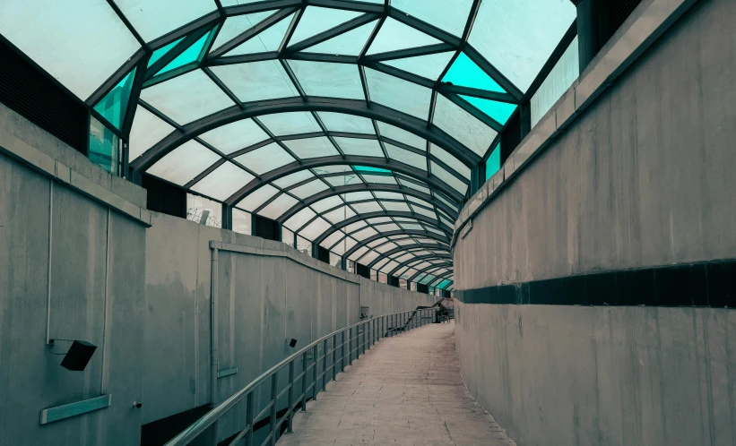 a walkway next to wall with glass windows in it