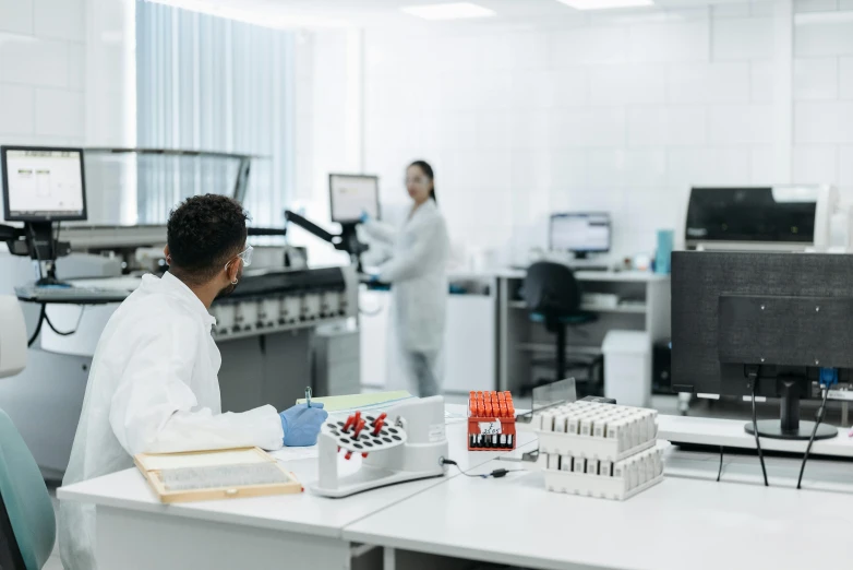 two people are working in a lab near some electronics