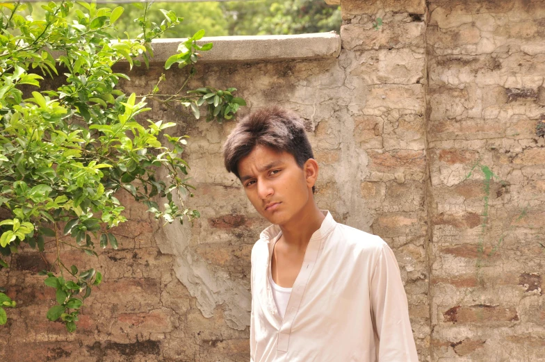 a man standing in front of a brick wall