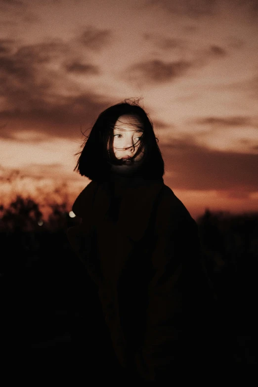 a man standing in the dark at dusk with a face painted on