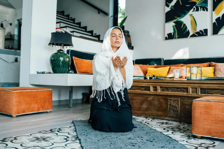 an oriental woman sitting down doing the prayer