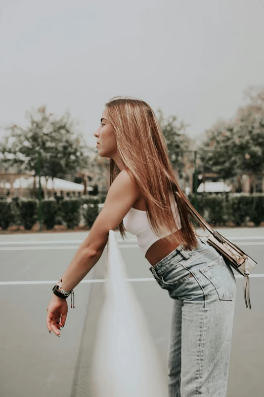 a woman is standing on the tennis court looking at soing