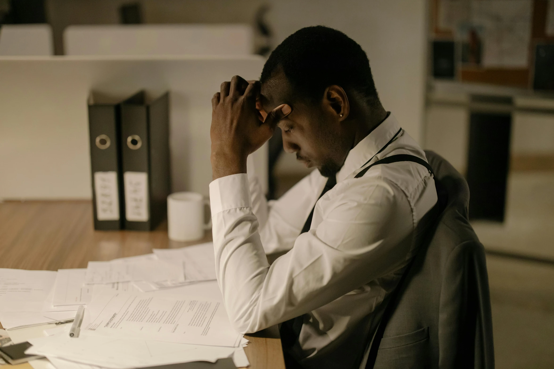 a man sits at his desk looking very bored