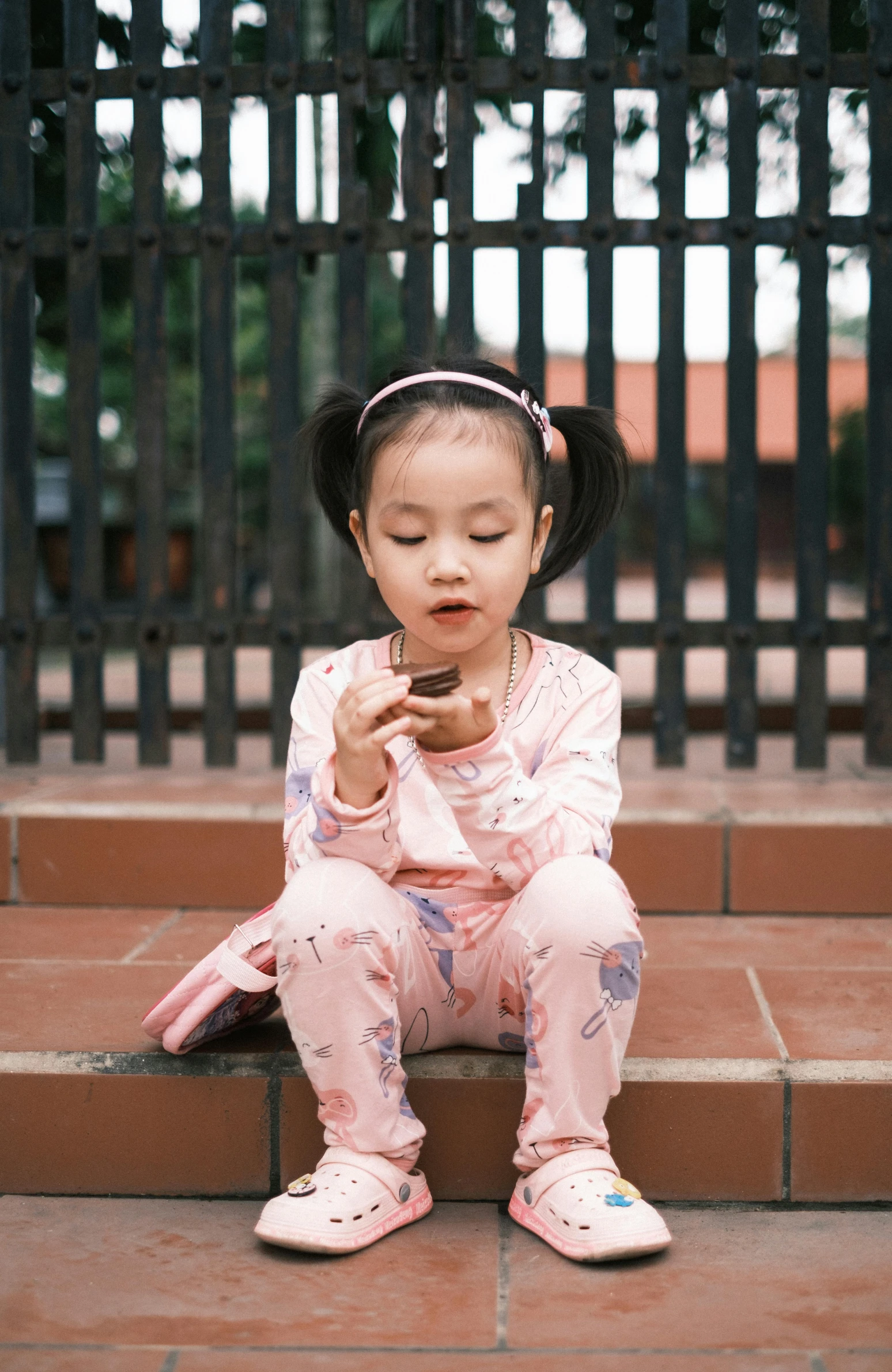 a girl sits on stairs playing on her phone