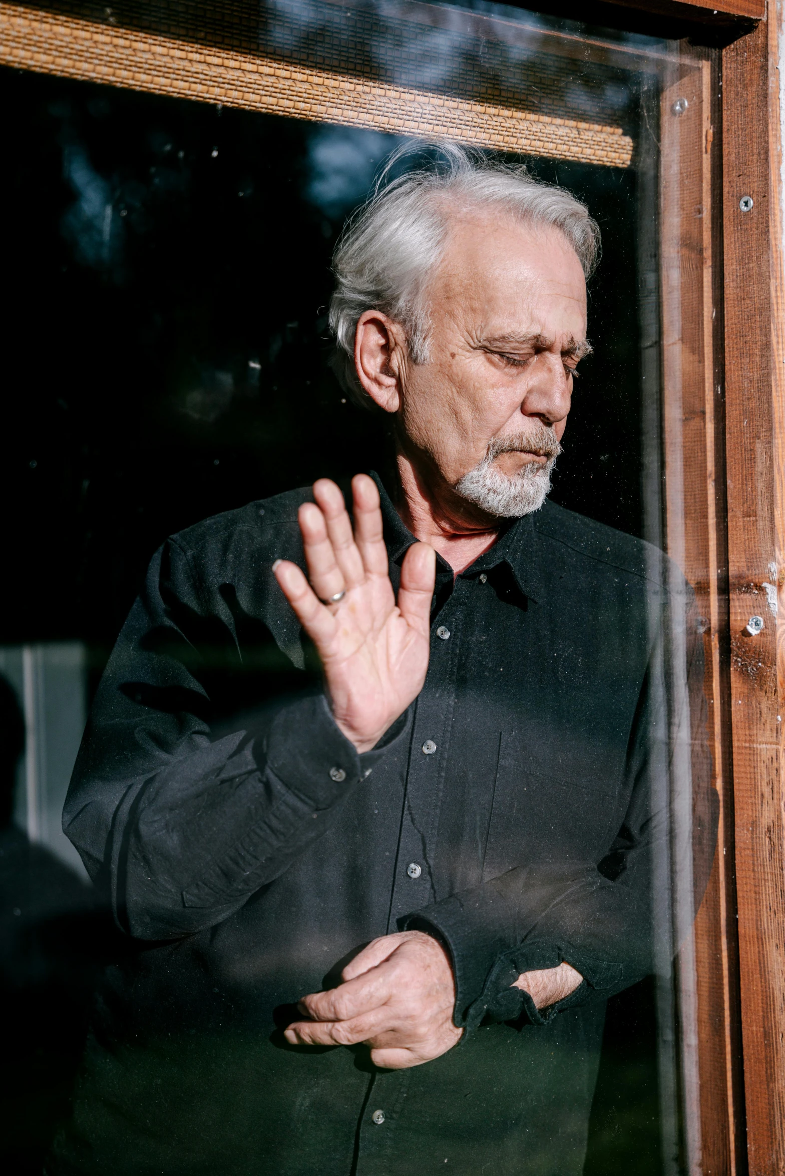 a man in a black shirt with his hand on his chest