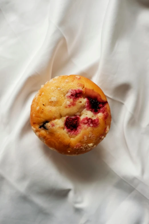 a close up of a muffin on a white sheet