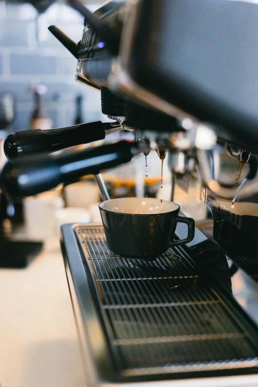an espresso machine pouring  coffee in a cup
