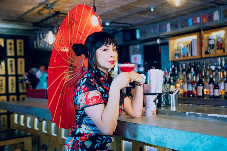 a woman with an umbrella and a drink in hand