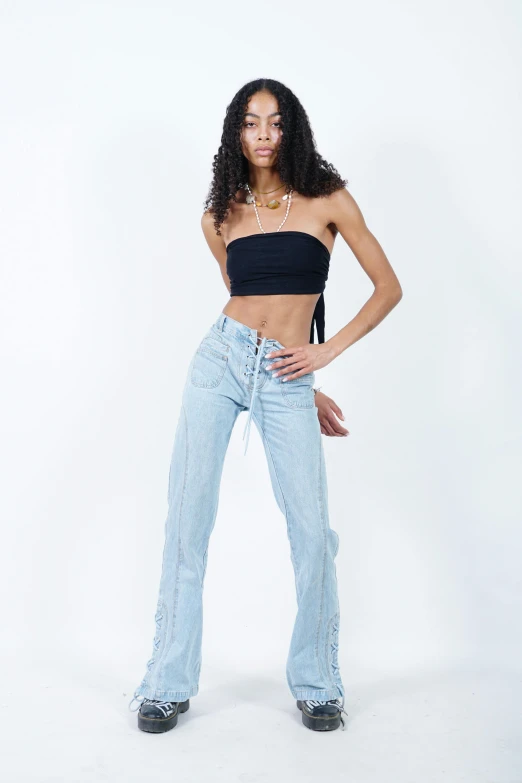 a young woman is posing in jeans and top