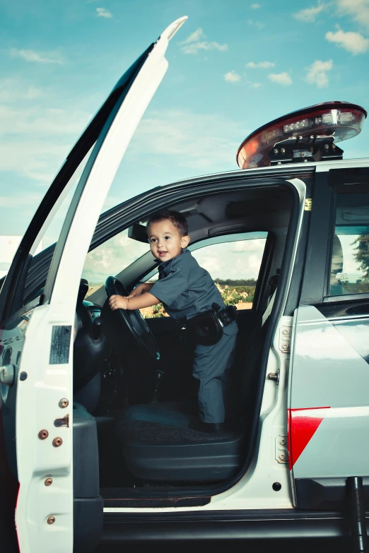 a child is sitting in the drivers seat of a small truck