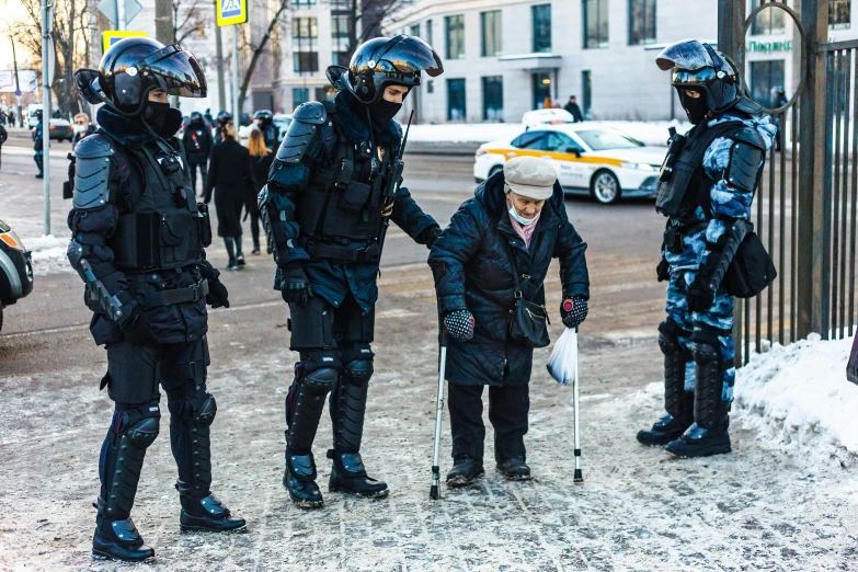 group of policemen dressed in full gear on sidewalk near fence