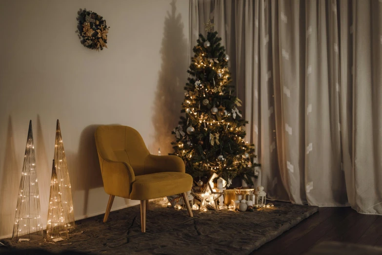 a christmas tree in a living room by a chair