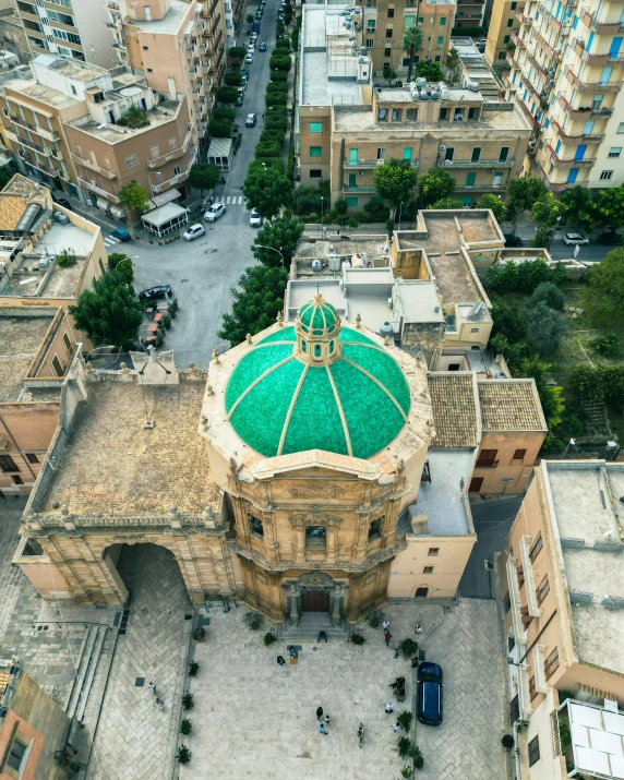 an aerial view of a green dome on a tall building