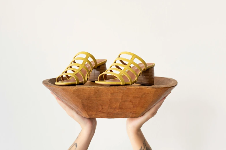 yellow women's shoes on top of a wooden stand