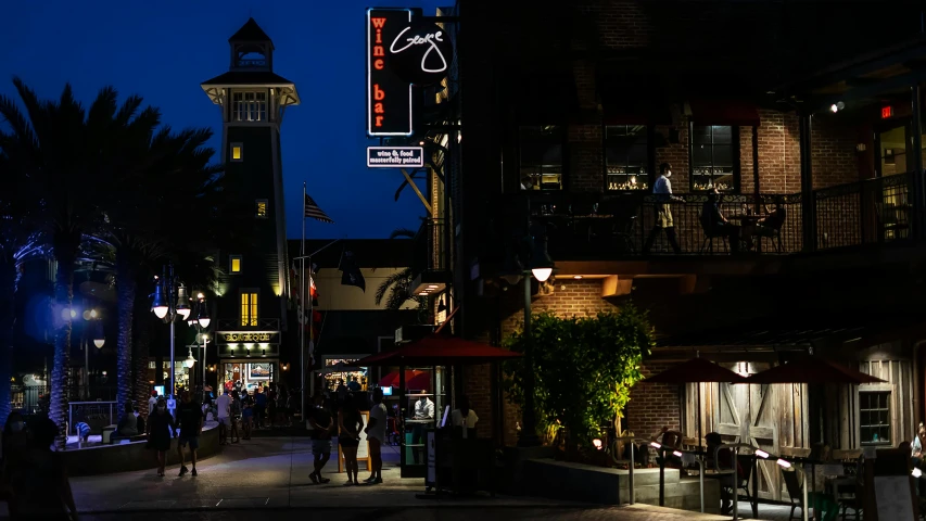 people are walking around a lit up shopping district