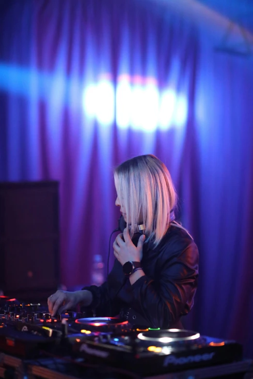 a woman is working at an dj mixer