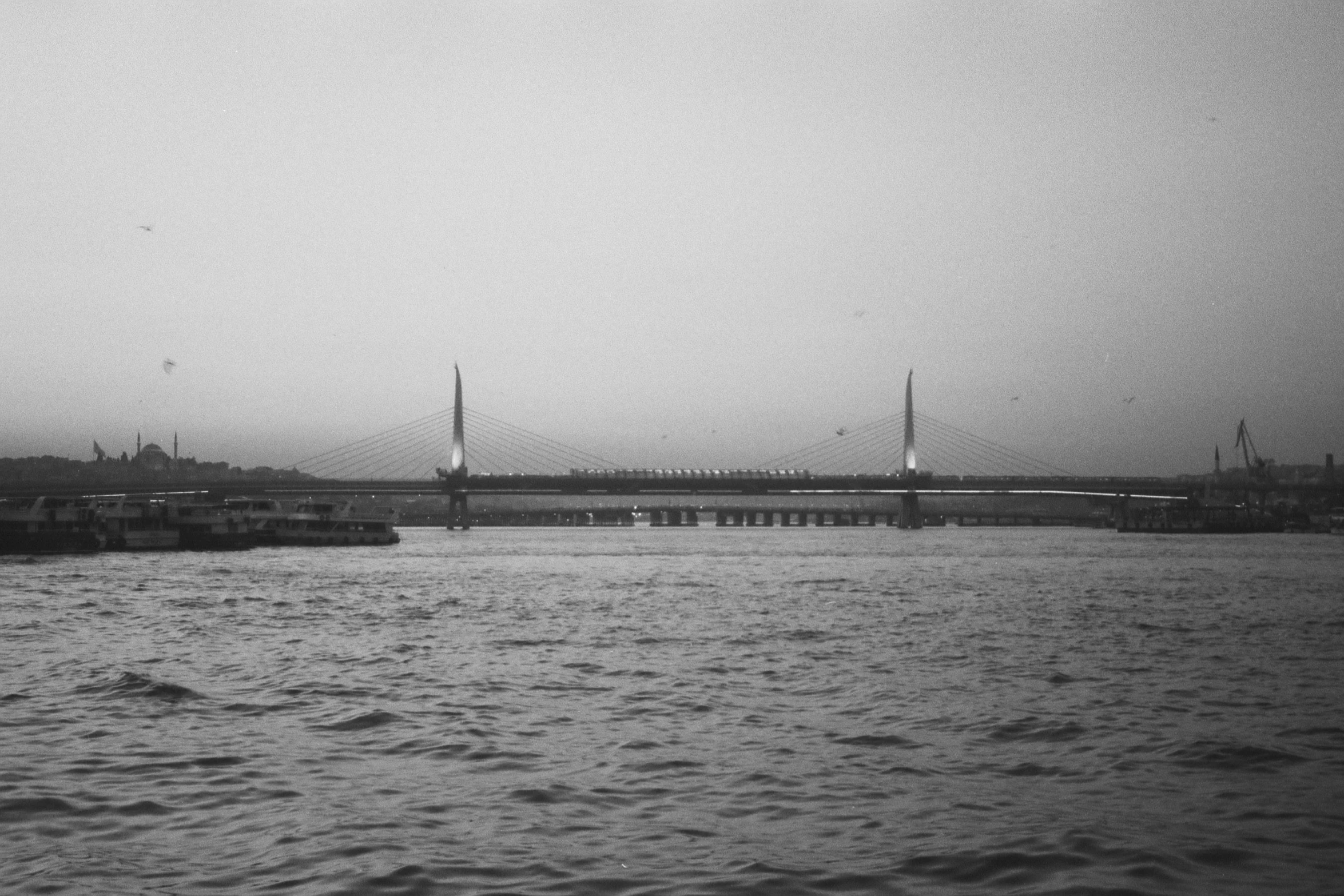 the water with boats on it and a bridge behind it