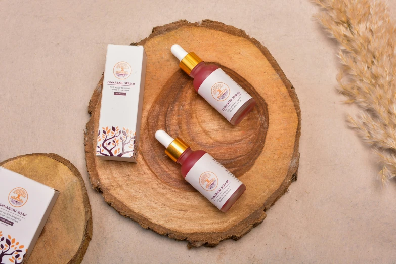 two bottles of body lotion sitting on top of a wooden slice