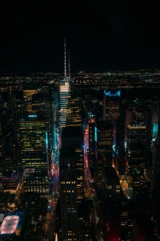 view from top of skyscrs at night looking down on new york city