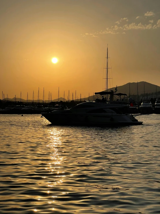 the sun is setting over a large boat harbor