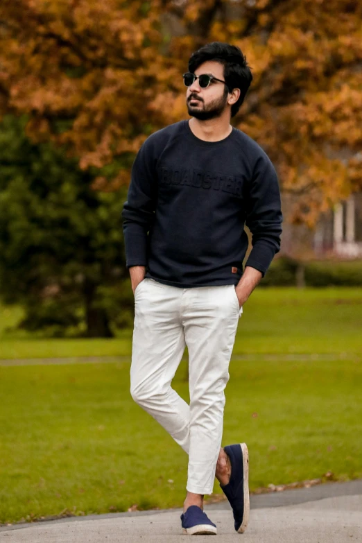 a man walking down the street in a black sweater