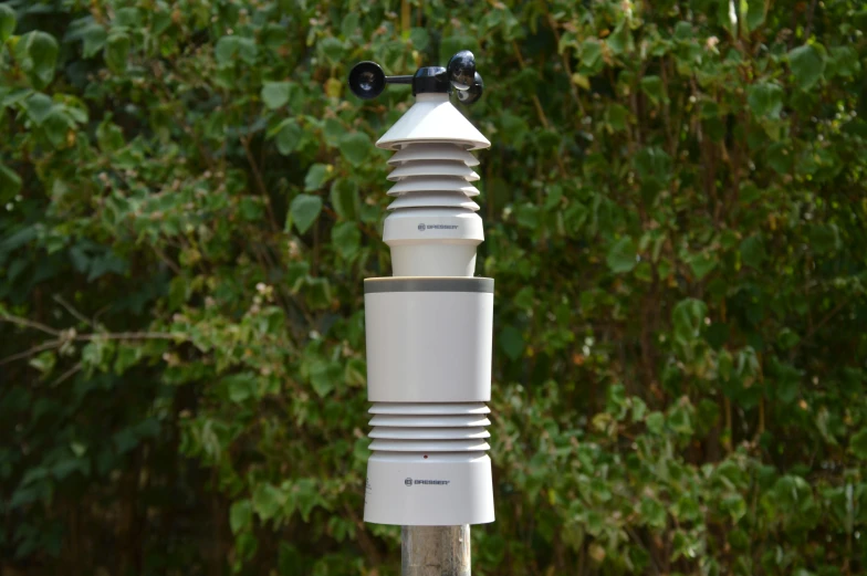 the view of a white and silver plastic water fountain in a garden area