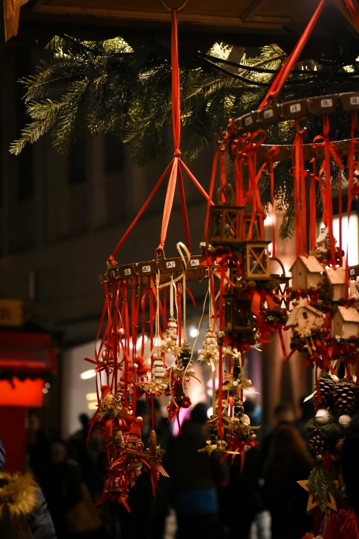 christmas decorations hanging from a ceiling with people in the background