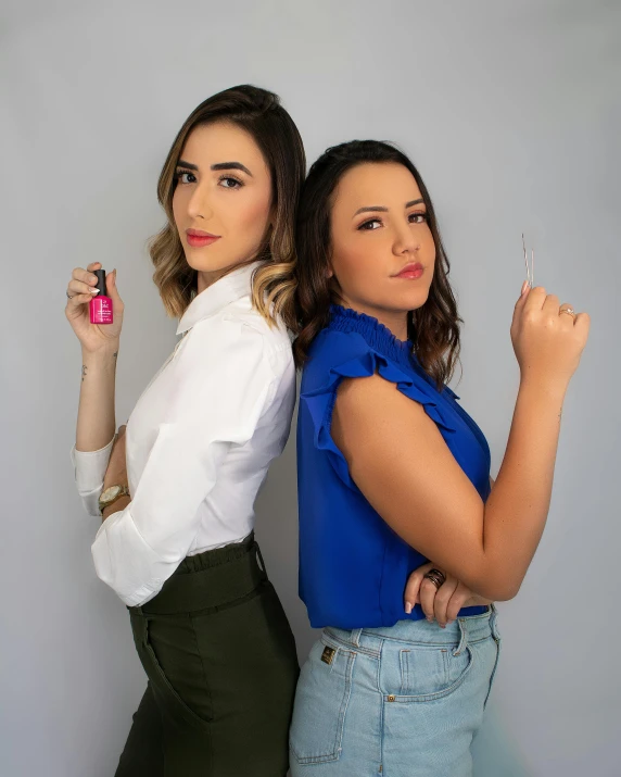 two young women who are holding up pink plastic forks