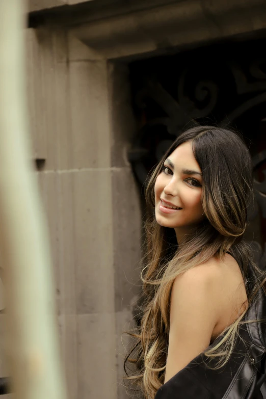 a woman in a very long dress smiling at the camera