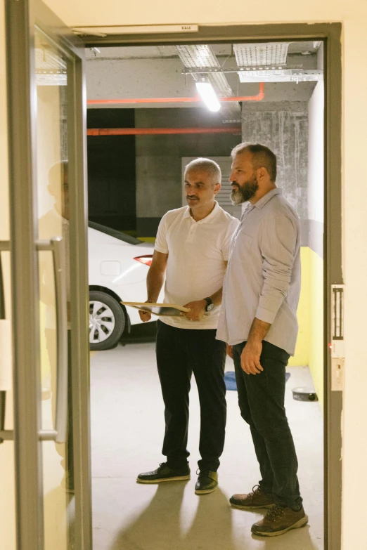 two men standing in a room with cars