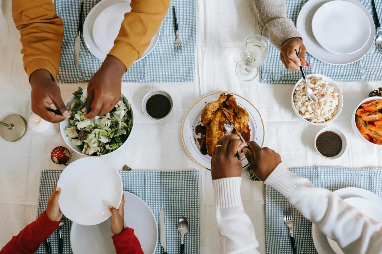 people sitting around a table with plates of food on it