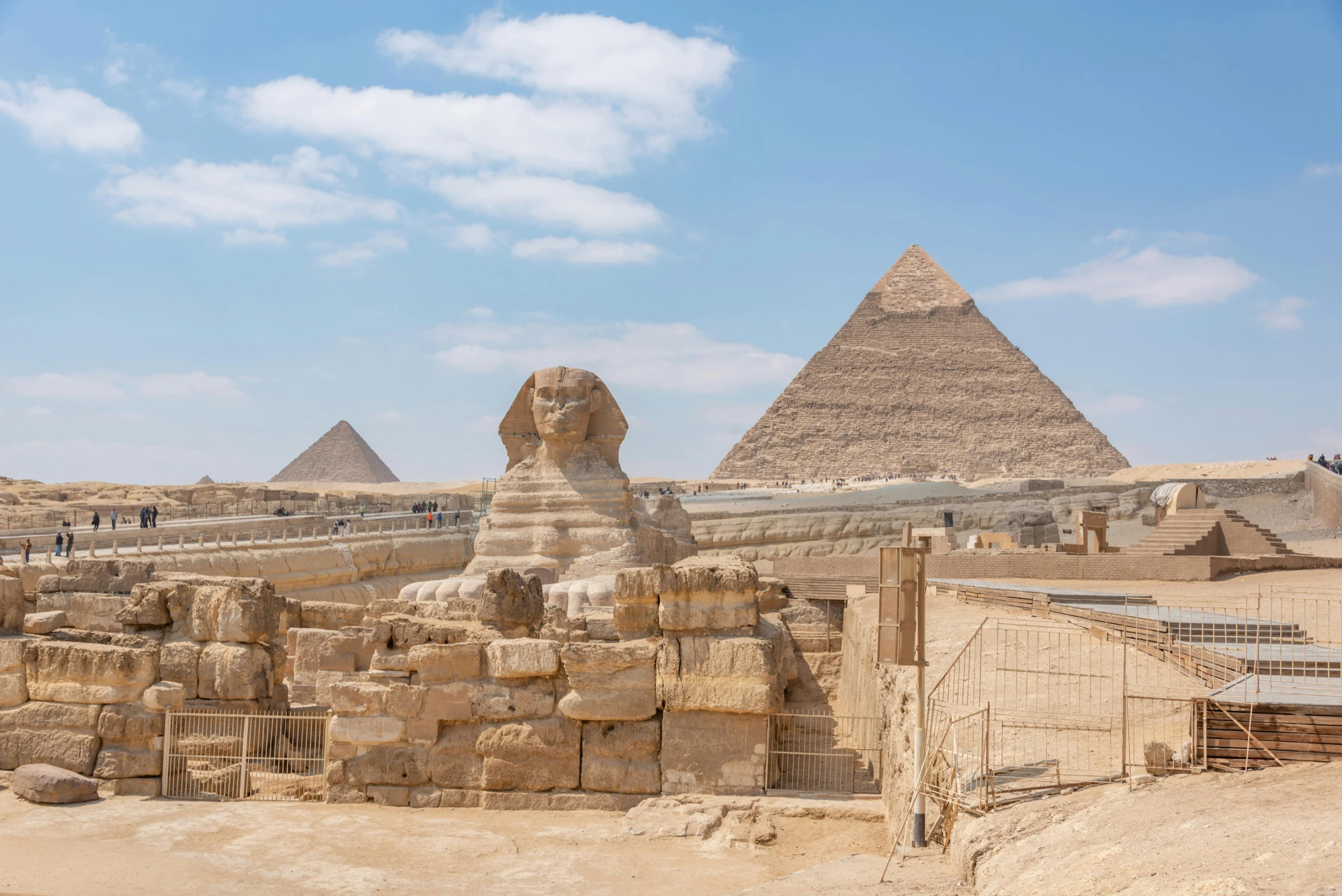 a stone sphinx sits atop the pyramids of giza