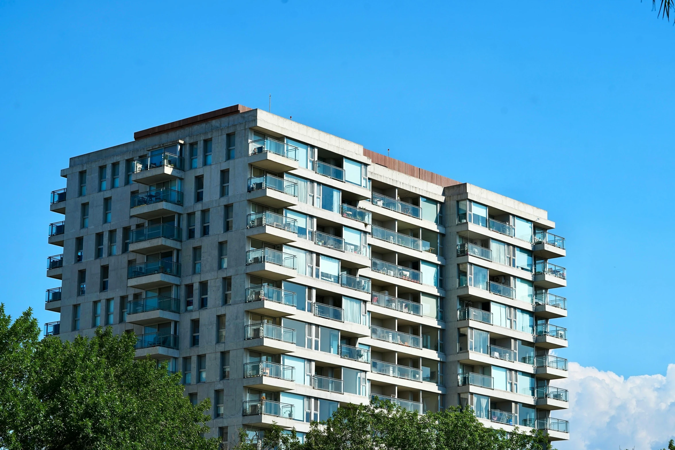 a very tall building surrounded by trees and blue sky