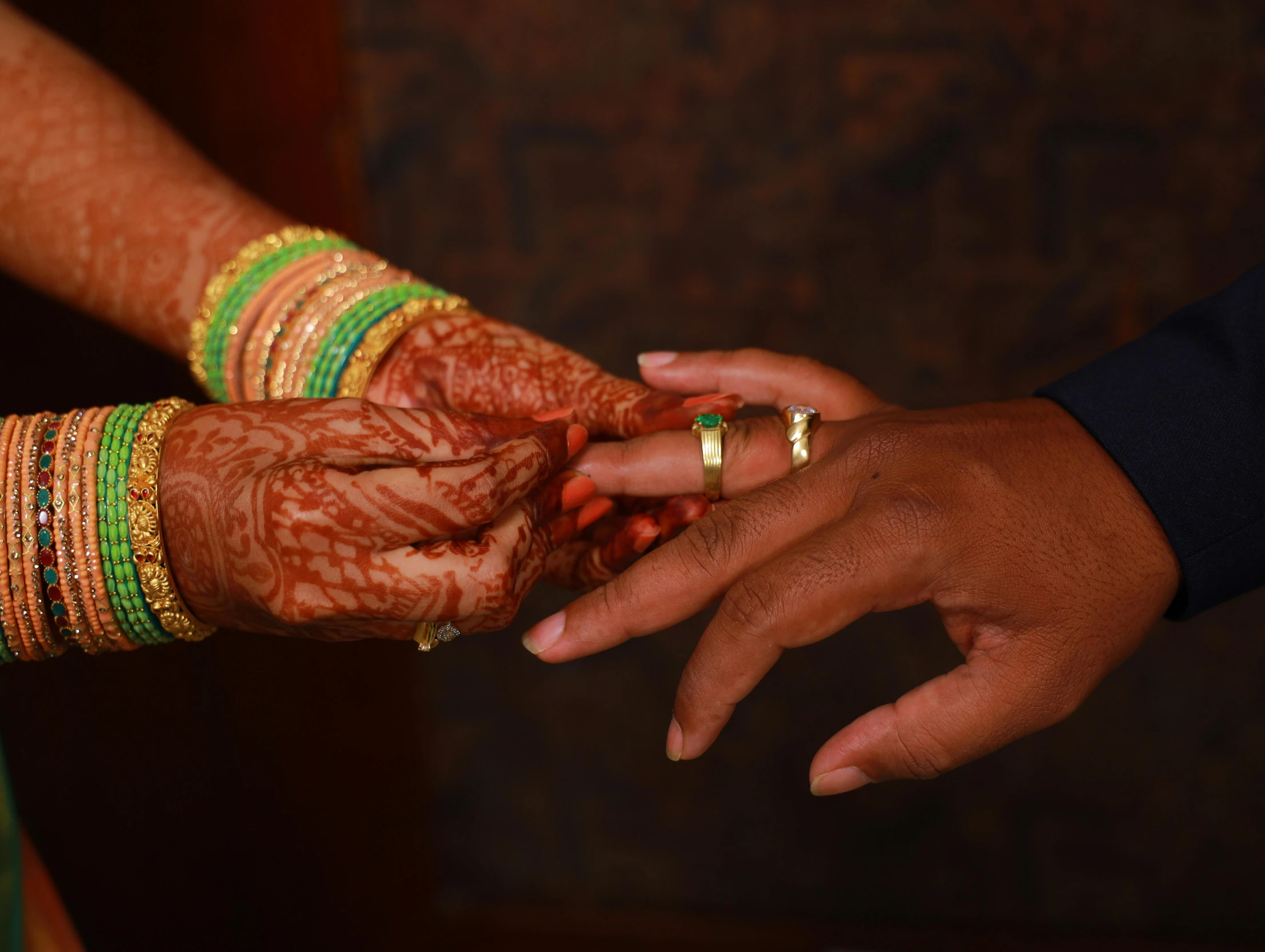 two people in green and yellow are holding hands