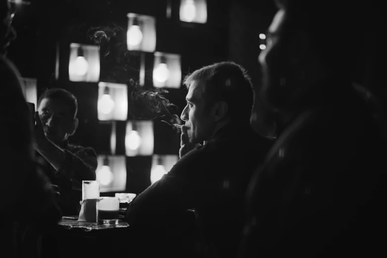 black and white po of people smoking at bar