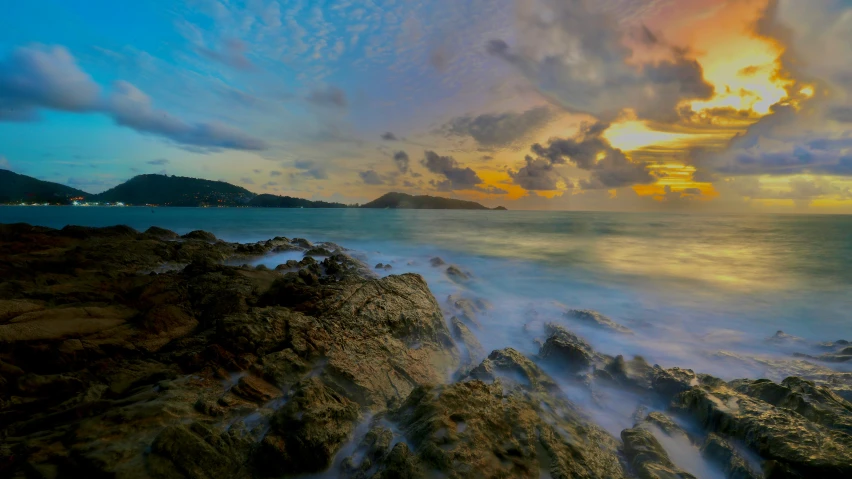 colorful sunset over the ocean as seen from a rocky coast