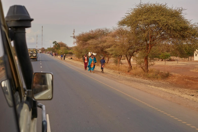 a group of people walk down the road