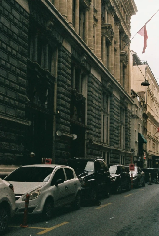 a street scene with several parked cars near a building