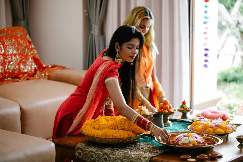 two women standing around a table full of food