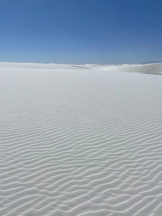 there is white sands and sky in the background