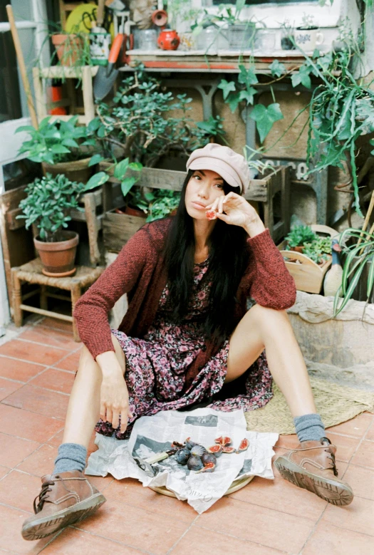 a woman sitting on the floor in front of plants