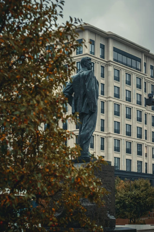 the building is very tall and the statue is near by